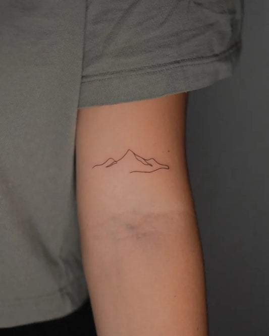 Tiny Minimalist Mountain Tattoo on Women Arm by @miautatts