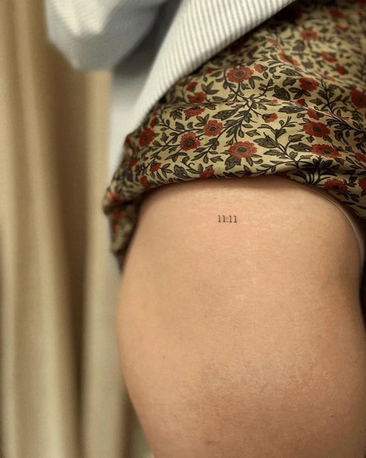 Tiny Minimalist Numbers on Women Thigh Tattoo by @lydiaamortattoo