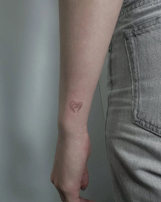 Tiny Minimalist Outline Heart on Women Wrist Tattoo by @aureatattoomadrid