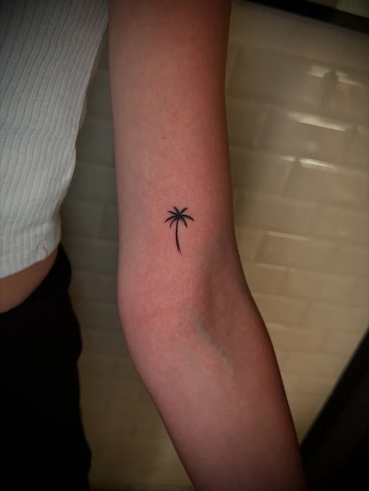 Tiny Minimalist Palm Tree Tattoo on Women Elbow by @fine_line_palermo