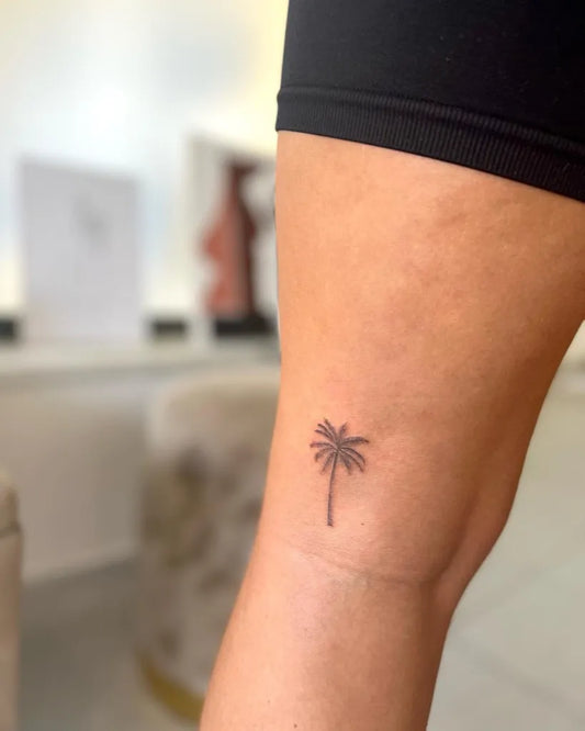 Tiny Minimalist Palm Tree Tattoo on Women Thigh by @mafaldadiego_