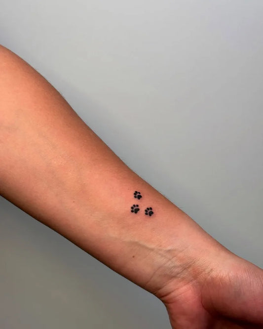 Tiny Minimalist Paw Prints on Women Wrist Tattoo by @_blackcattattoo_