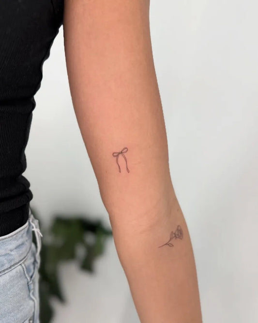 Tiny Minimalist Ribbon and Rose on Women Arm Tattoo by @deborahleall