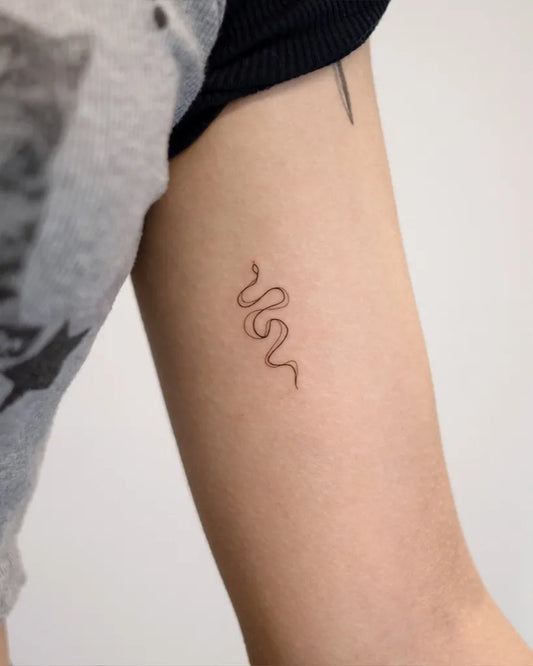 Tiny Minimalist Snake on Women Arm Tattoo by @handitrip