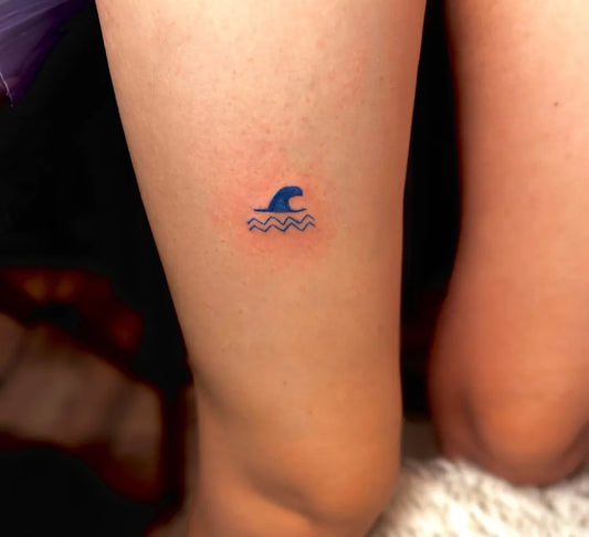 Tiny Minimalist SwimmingCap Wave Tattoo on Women Thigh by @lunaink.lab