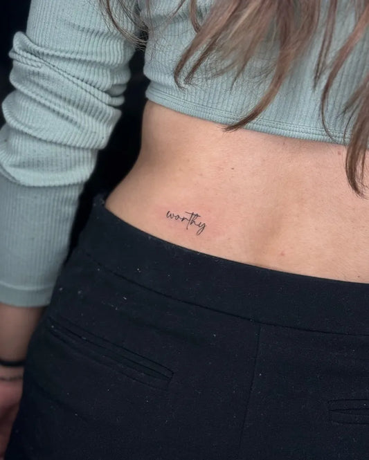 Tiny Minimalist Text on Women Lower Back Tattoo by @sea_of_ink_tattoo_studio