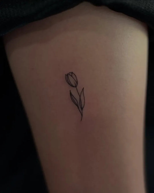Tiny Minimalist Tulip Flower on Women Thigh Tattoo by @ukiyotattooph