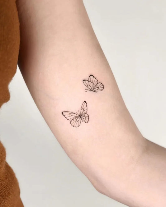 Tiny Minimalist Two Butterflies on Women Arm Tattoo by @cha.tattoo
