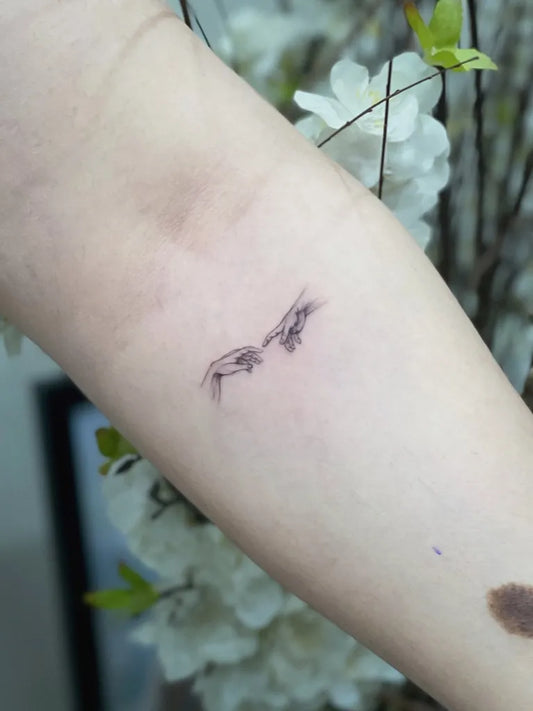 Tiny Minimalist Two Reaching Hands on Women Forearm Tattoo by @memo.tattooartist