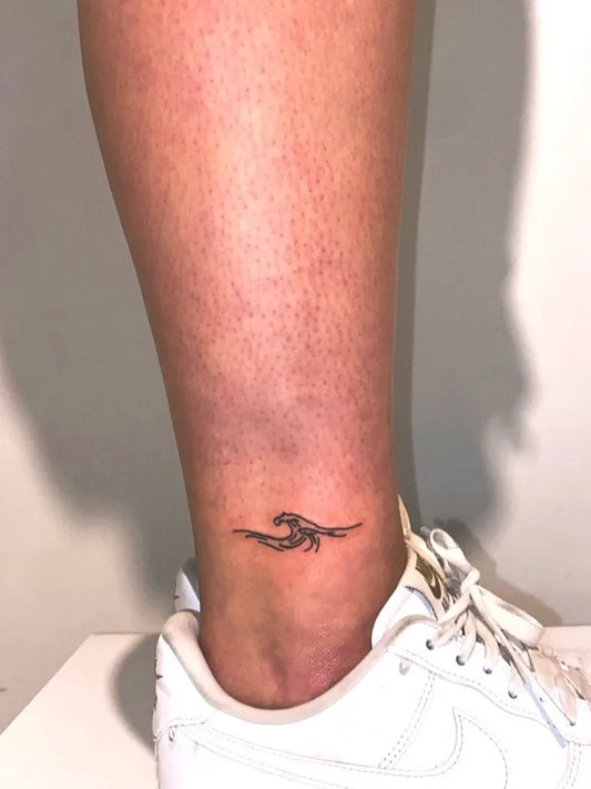 Tiny Minimalist Wave Tattoo on Women Ankle by @sam_tattooos