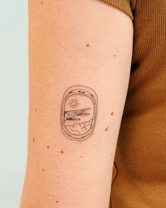 Tiny Minimalist airplane window with sun and clouds on Women Arm Tattoo by @alina_tattoo