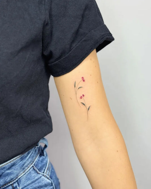 Tiny Minimalist cherry blossoms and branch on Women upper arm Tattoo by @eva_tattooist