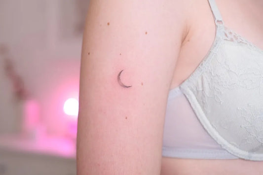 Tiny Minimalist crescent moon on Women arm Tattoo by @nomin.tattoo