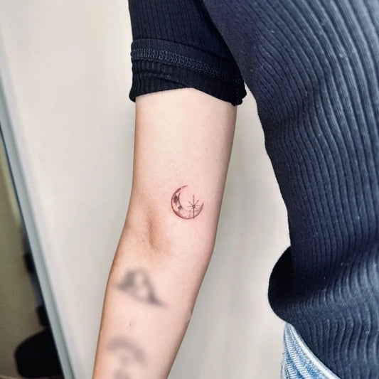 Tiny Minimalist crescent moon with stars on Women upper arm Tattoo by @dada__tattooist
