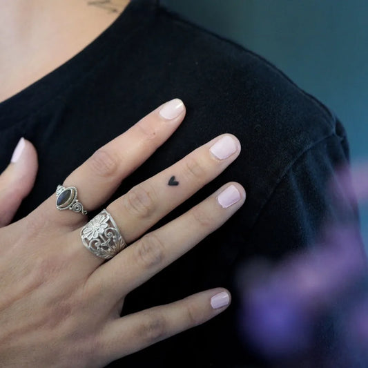 Tiny Minimalist heart on Women finger Tattoo by @traitsdunion_tattoo
