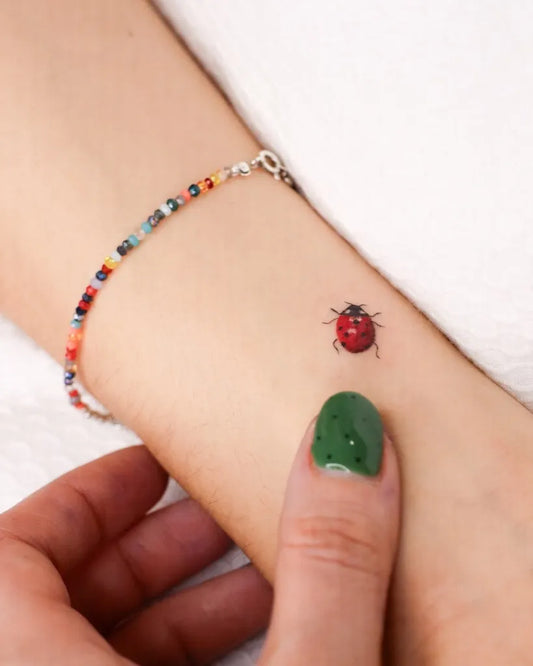 Tiny Realism Ladybug Tattoo on Women Wrist by @india.tatt