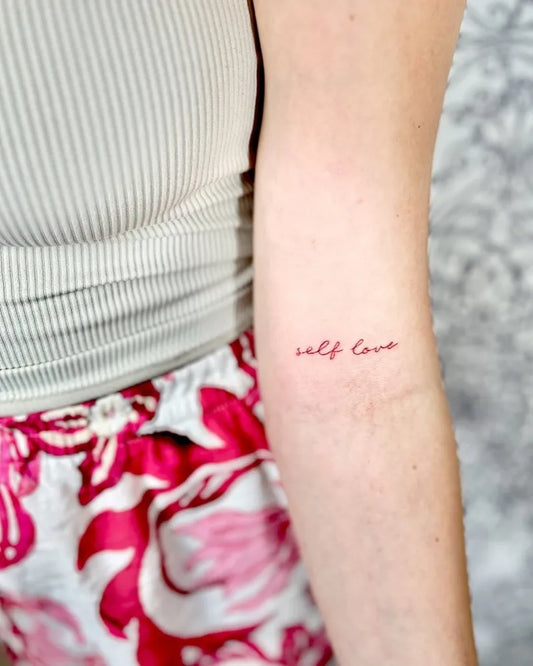 Tiny Red Self Love Script Tattoo on Women Arm by @sina.welcher.kosmetik.tattoo
