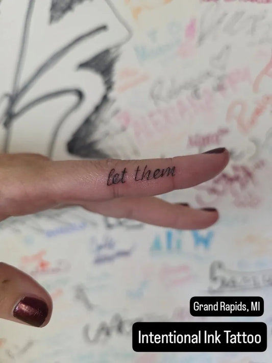 Tiny Script Let Them on Women Finger Tattoo by @zacharyanzivino