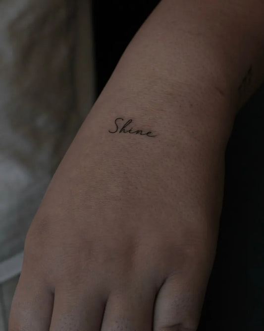 Tiny Script Shine Word on Women Wrist Tattoo by @cerentoyran.ink