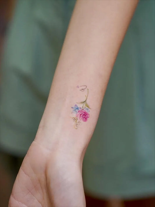 Tiny Watercolor Flowers and Stem on Women Wrist Tattoo by @hye.artt