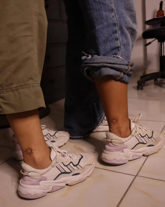 Tiny sun on couple ankle matching Tattoo by @tattoobychristina