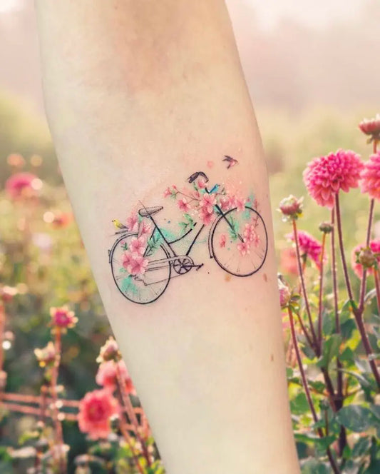 watercolor floral bicycle tattoo on forearm