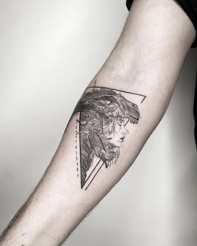 black and grey geometric woman monster tattoo on inner forearm
