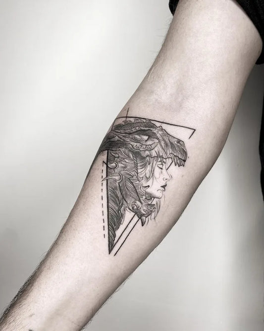 black and grey geometric woman monster tattoo on inner forearm