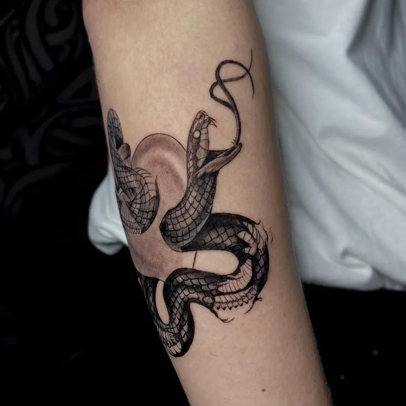 black and grey snake tattoo on arm