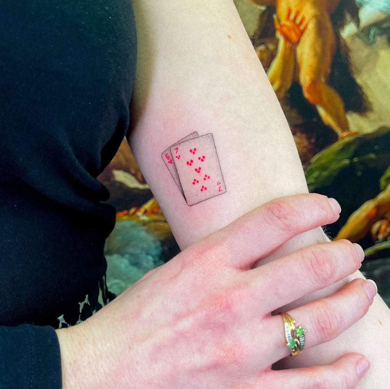 micro realism red poker cards minimalist tattoo on woman bicep