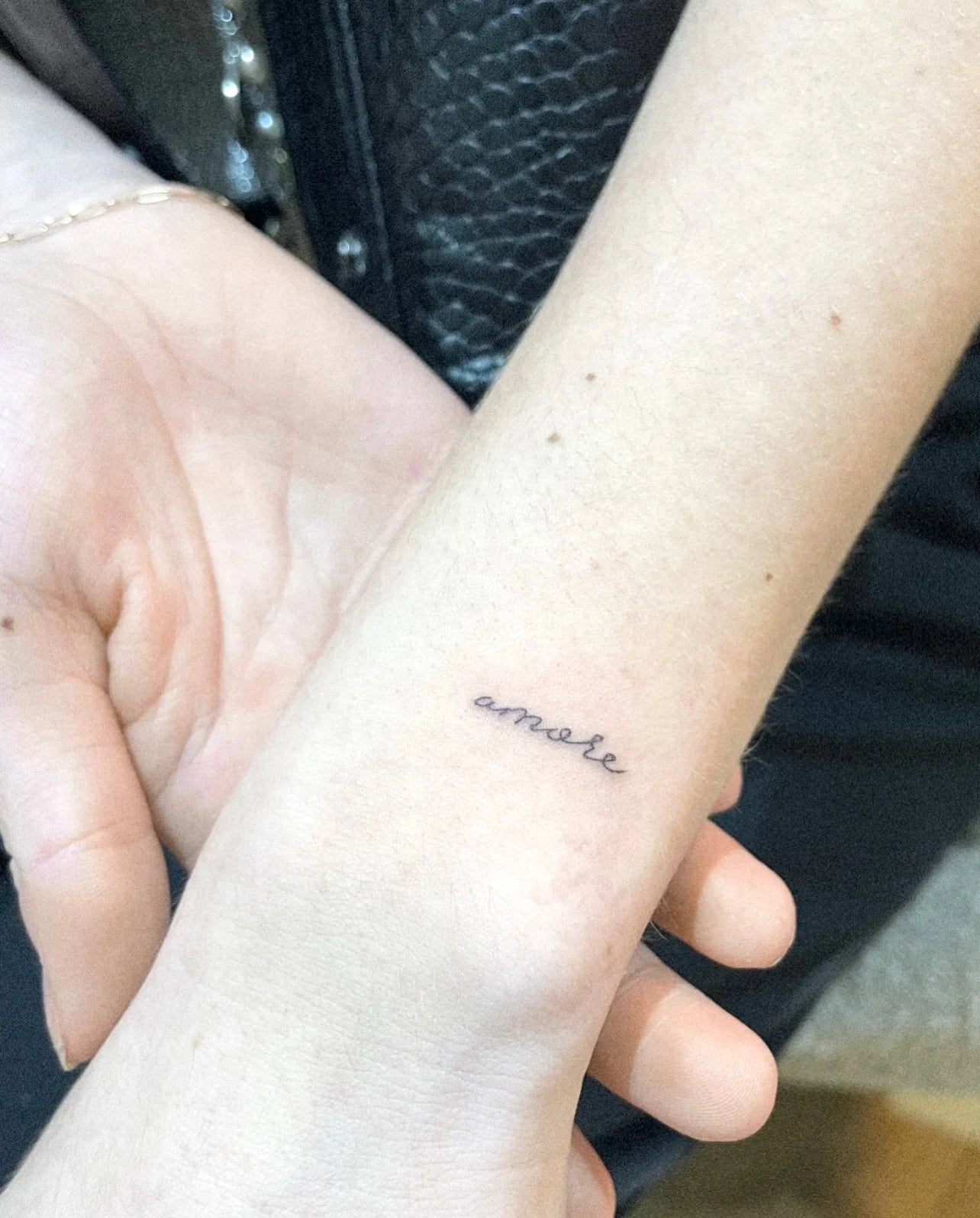 minimalist single needle lettering tattoo on woman wrist