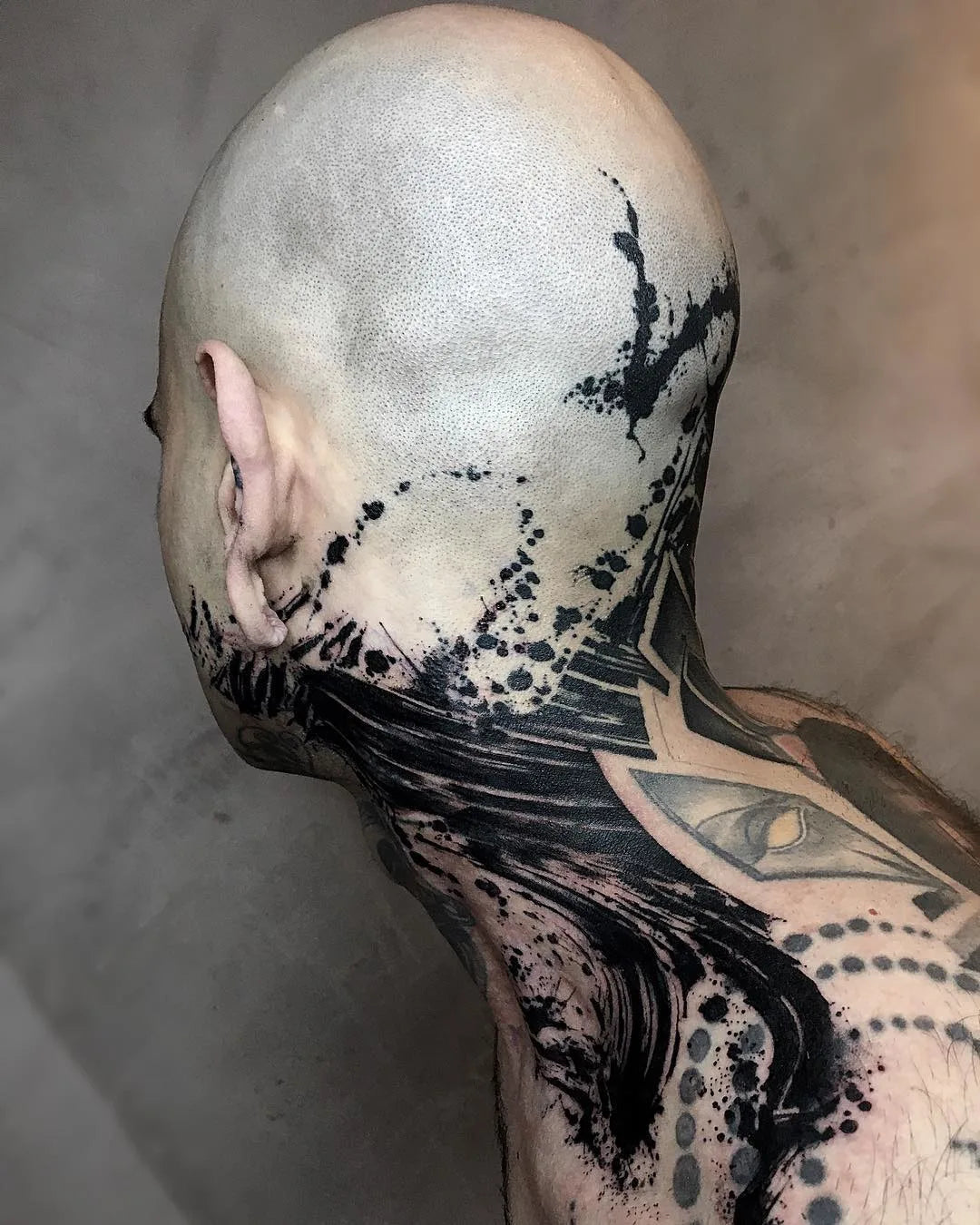 black ink splashes watercolor brush stroke blackwork tattoo on man head and neck