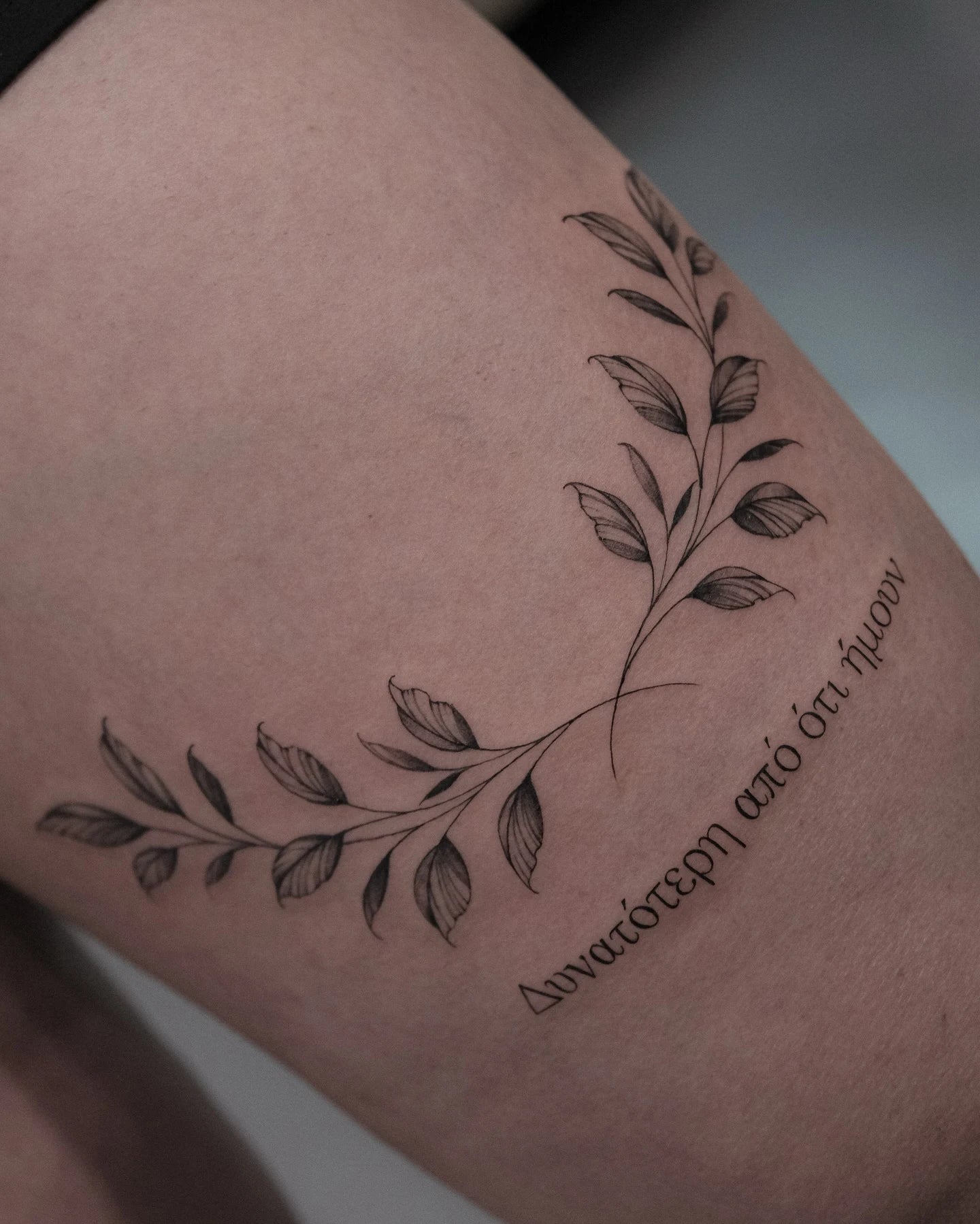 fine line leaves tattoo on woman thigh