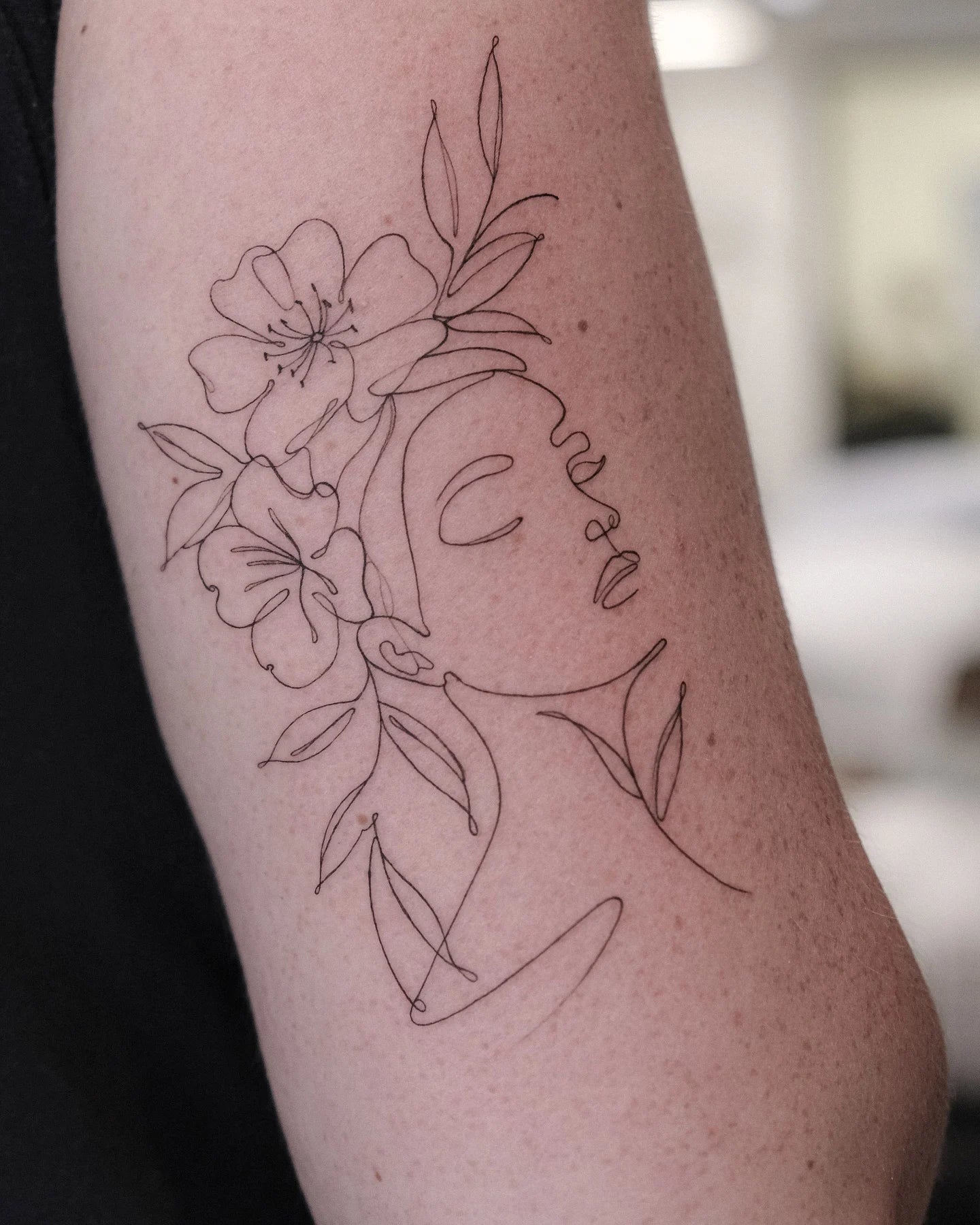 abstract one line fine line woman face with flower tattoo