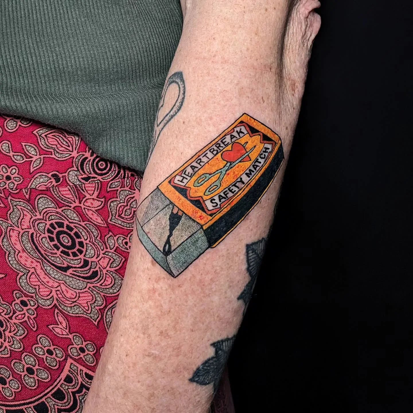 neo traditional safety match box tattoo on old woman forearm