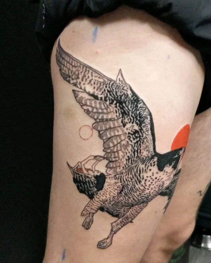 woman lying on big bird tattoo on thigh