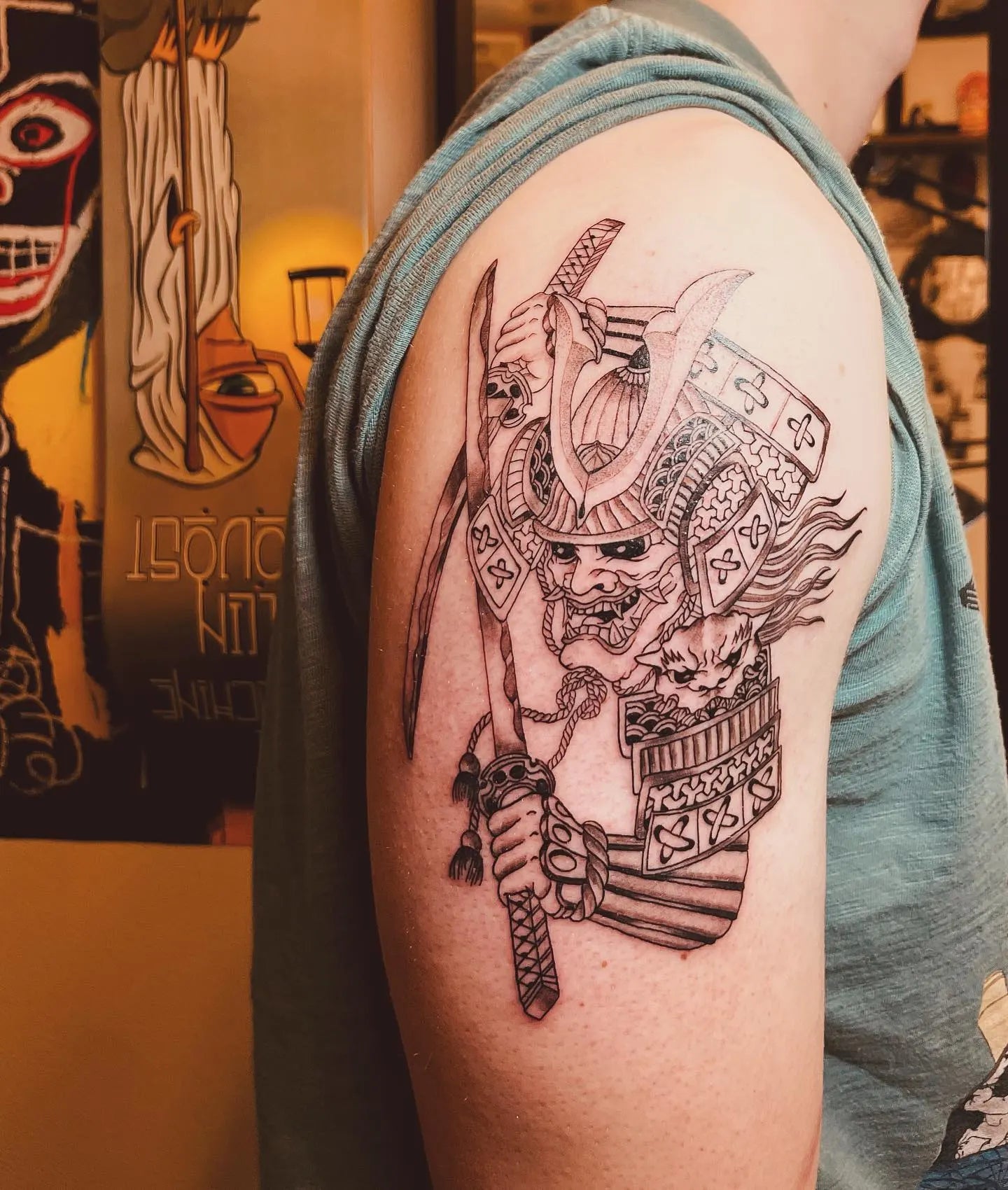 japanese warrior with helmet outline tattoo on man upper arm