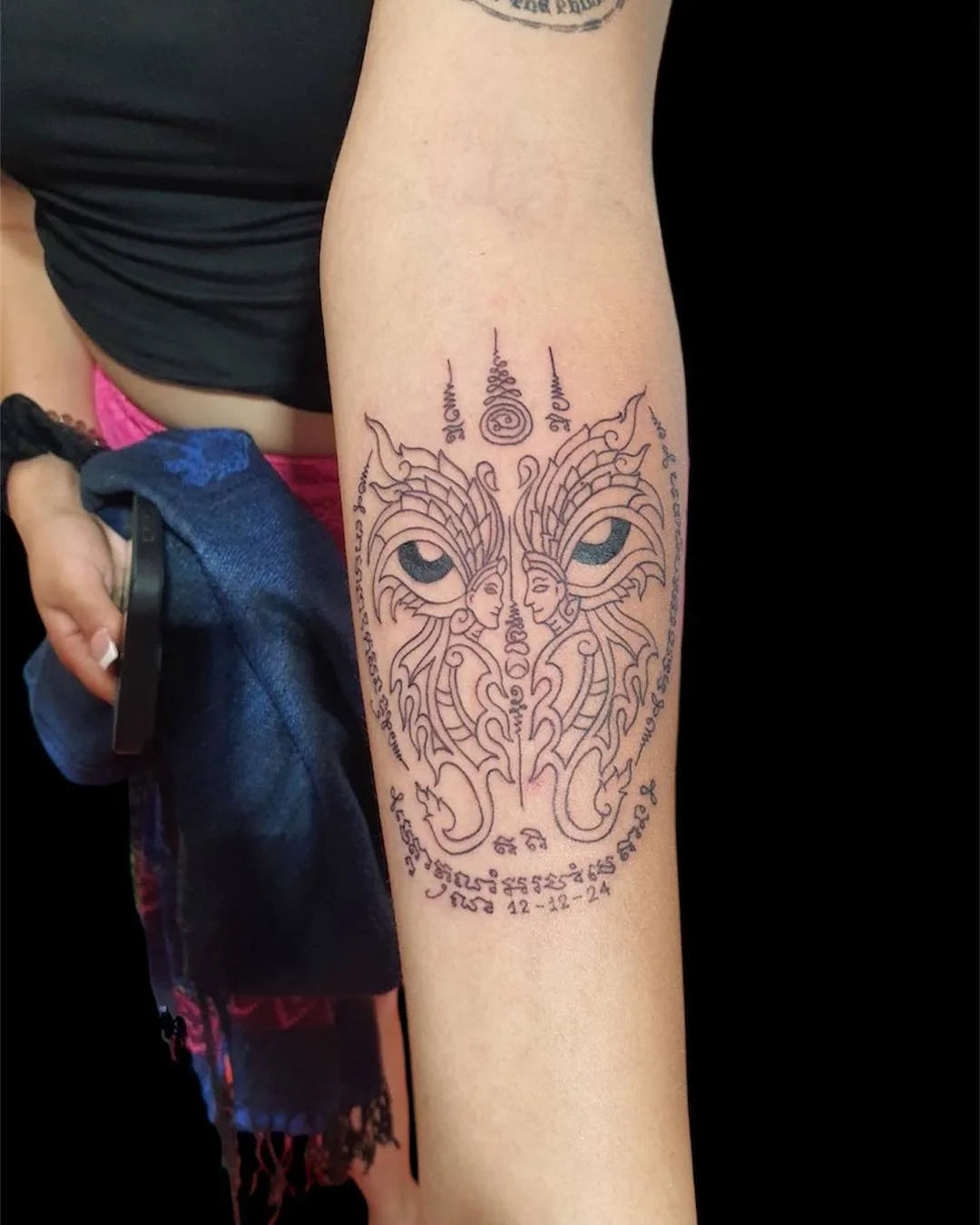 thai traditional outline tattoo on woman forearm