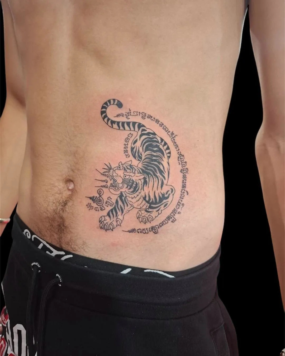 thai sak yant tiger tattoo on man stomach