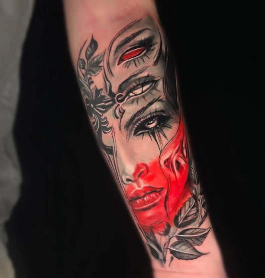abstract woman face with red accents forearm tattoo