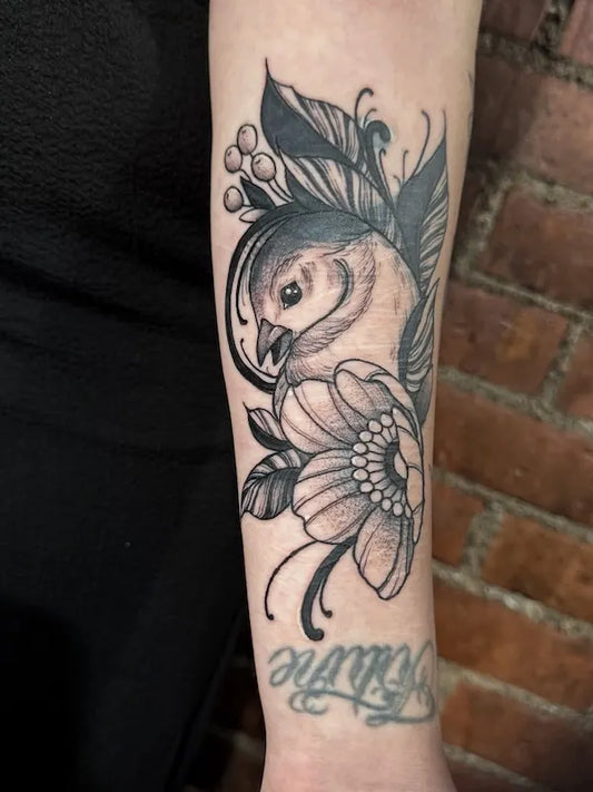 Bird and Anemone flower black and grey tattoo on woman inner arm