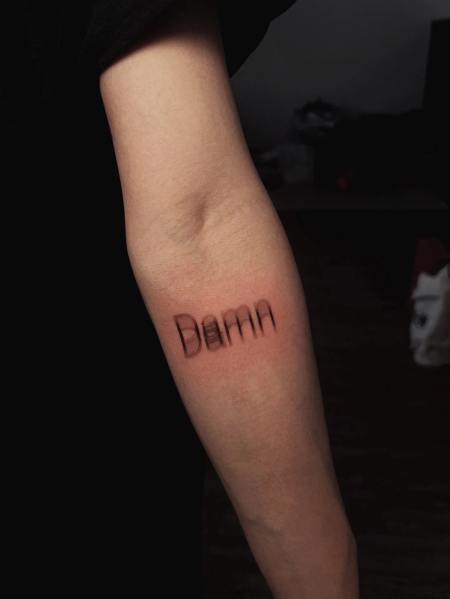blurry damn lettering tattoo