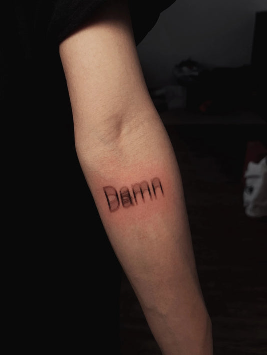 blurry damn lettering tattoo
