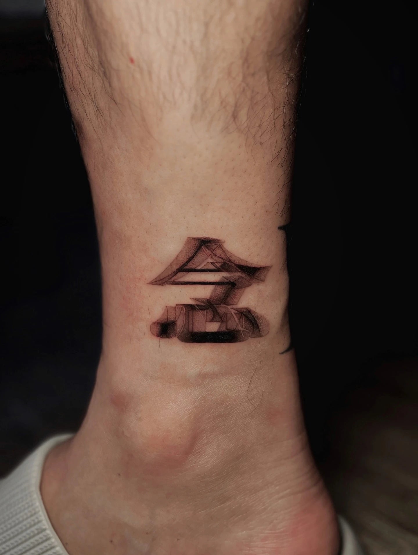 blurry Chinese 念 lettering tattoo