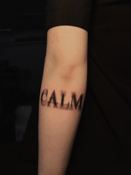 blurry calm lettering tattoo