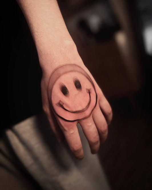 blurry smiley emoji tattoo