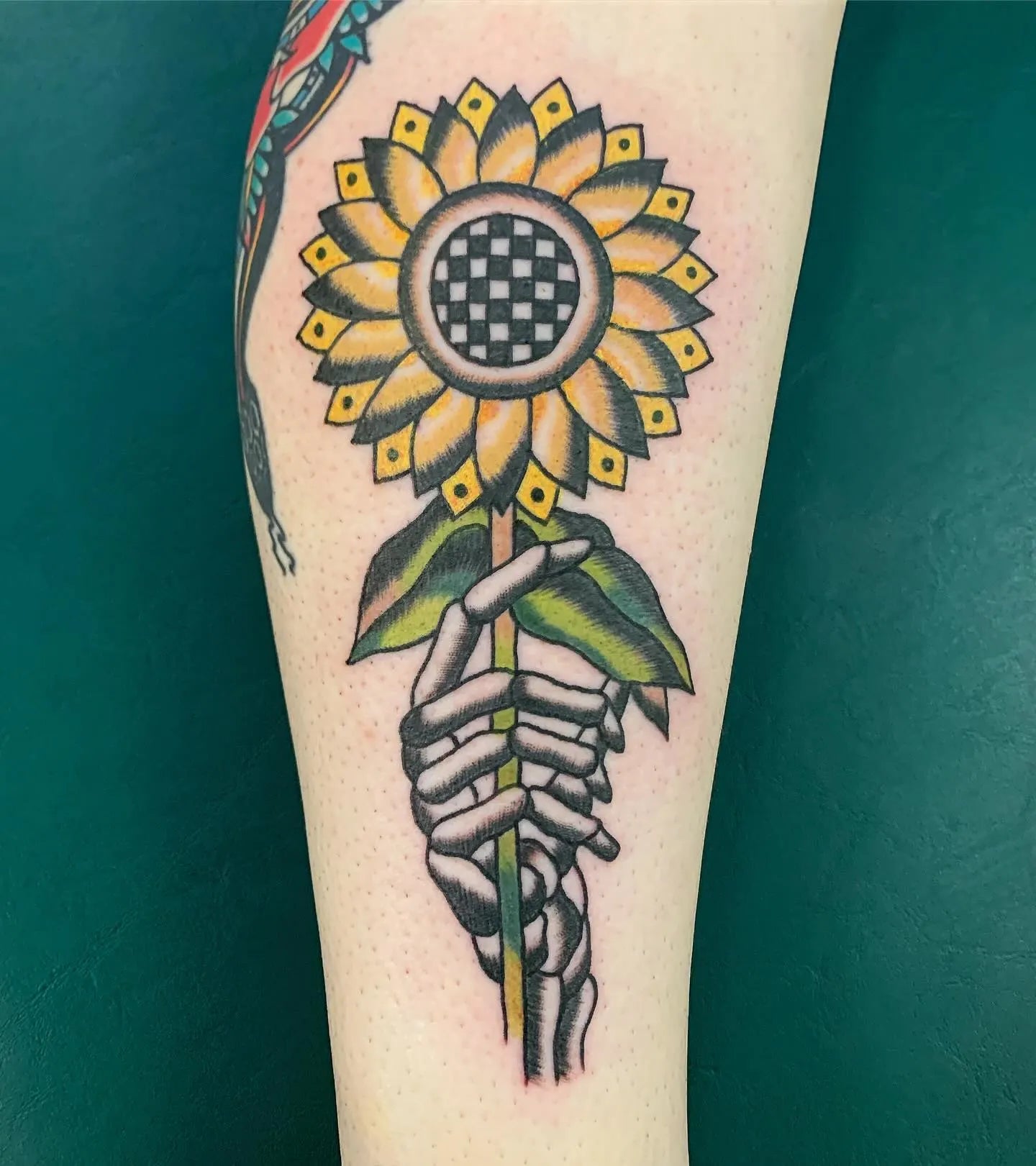 skeleton hand holding sunflower tattoo