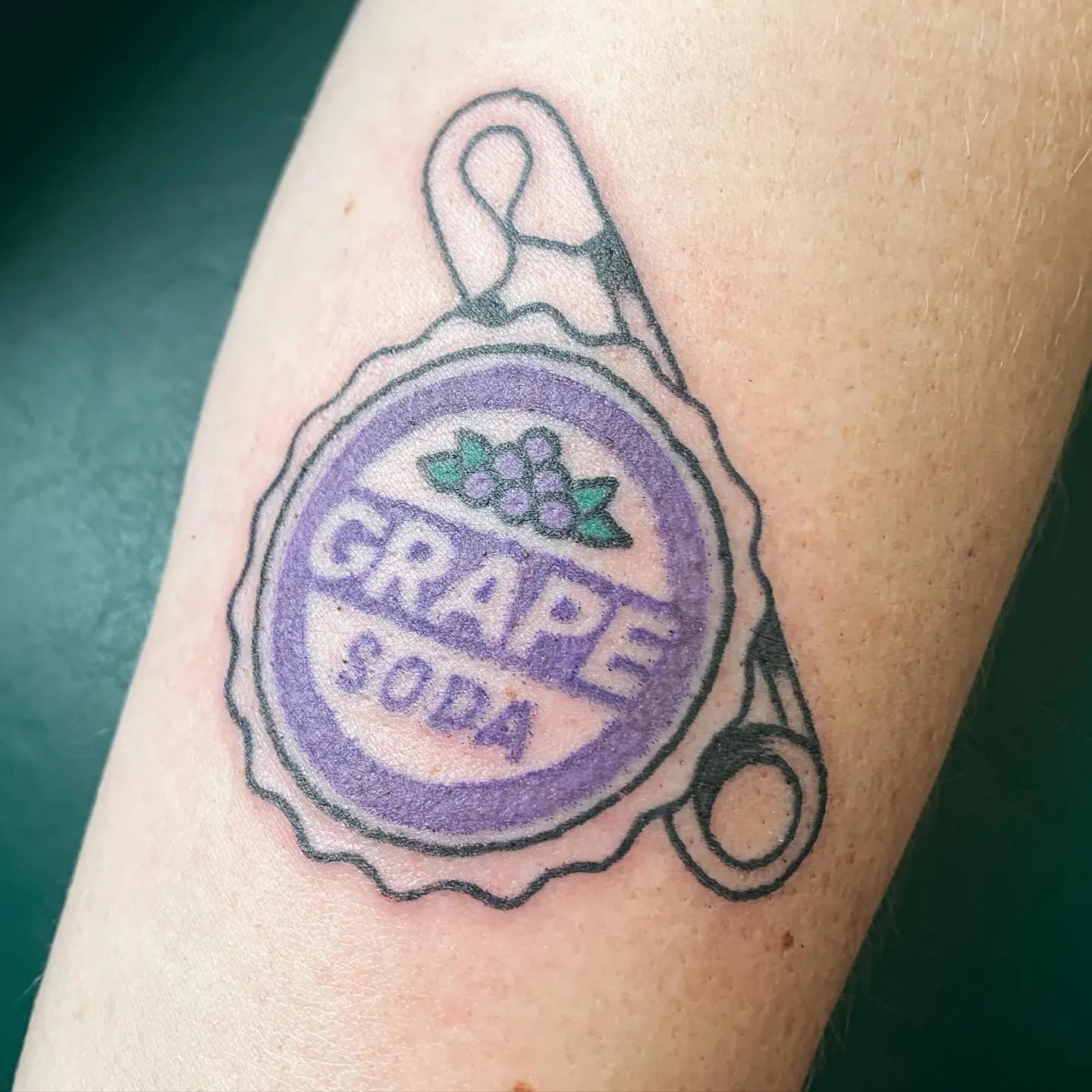 Tattoo of a grape soda bottle cap