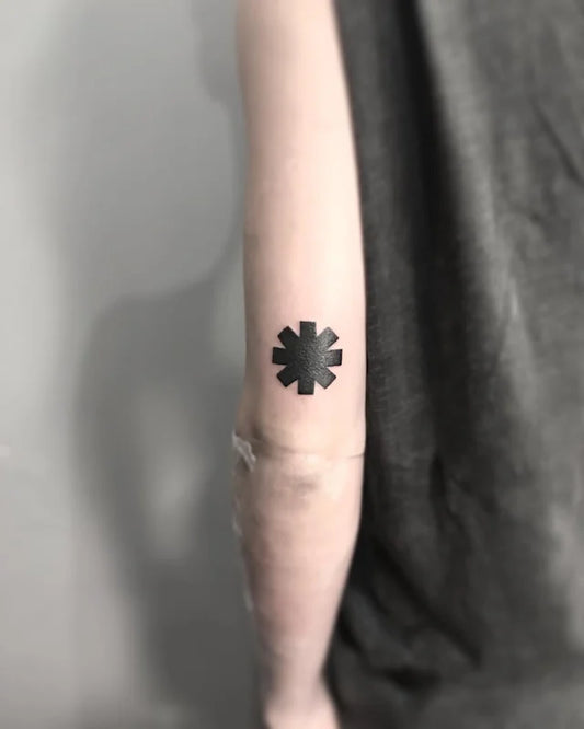 Black asterisk star blackwork tattoo on arm back red hot chilli pepper