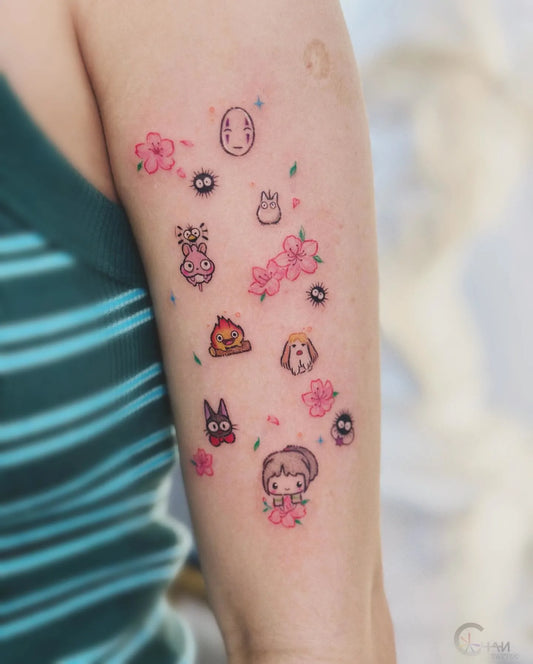 colorful minimalist small tattoos of cartoon characters and flowers on woman upper arm